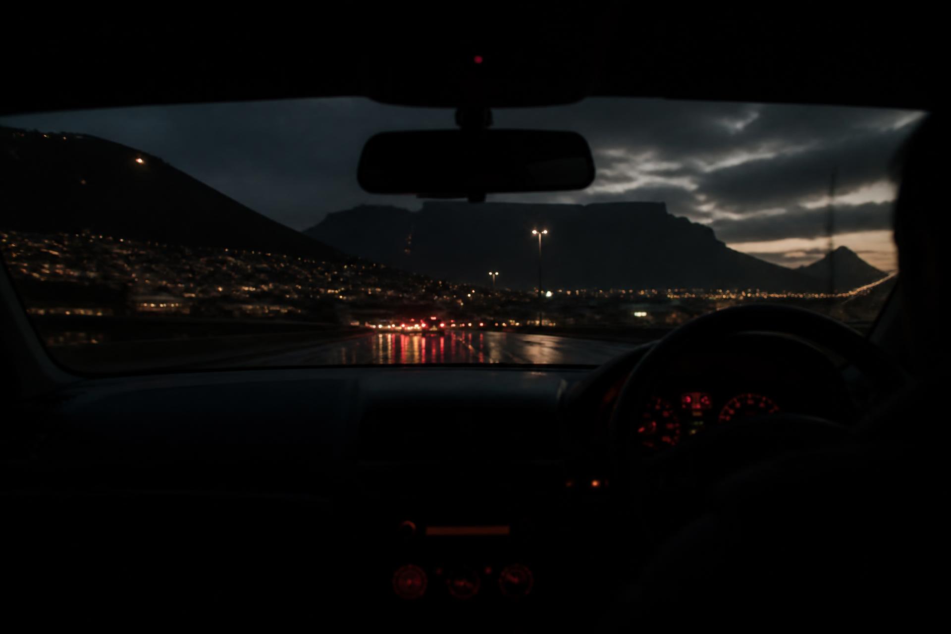 Driver's view from inside a dual-control learner car on a Cape Town road at dusk